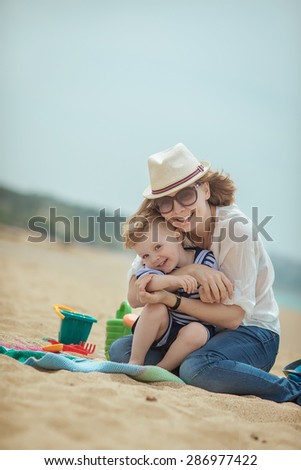 young beautiful mother with her little boy on the beach