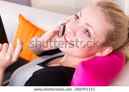 Beautiful blond girl gossiping on the phone aat home