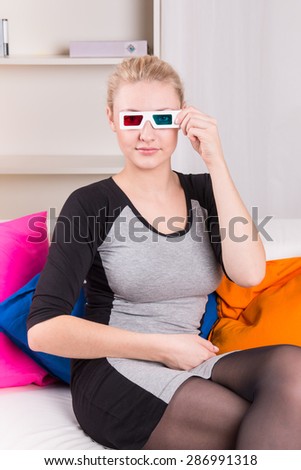 Woman watching a 3D movie with colored glasses at home 