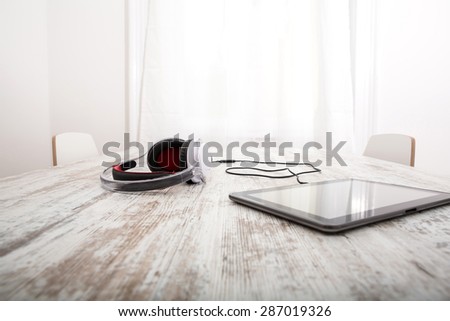 A Tablet PC with headphones on the Table.