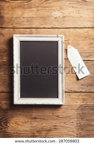 White picture frame on a floor. Studio shot on a wooden background.