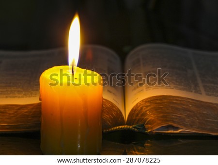 Yellow candle light with the holy bible in dark background Royalty-Free Stock Photo #287078225