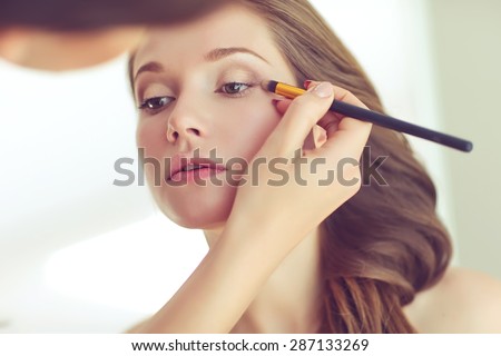 Backstage scene: Professional Make-up artist doing glamour model makeup at work  Royalty-Free Stock Photo #287133269