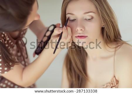 Backstage scene: Professional Make-up artist doing glamour model makeup at work  Royalty-Free Stock Photo #287133338