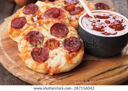 Mini pizzas with salami, cheese and tomato