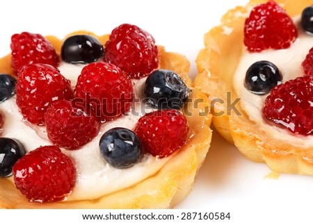 Sweet cakes with berries on white background