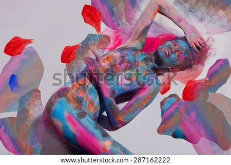 Young lady with body art lying on a watercolour background with pink red and blue