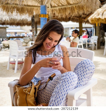 Beautiful young woman enjoying the outdoors in a tiki style restaurant setting in the Florida Keys.
