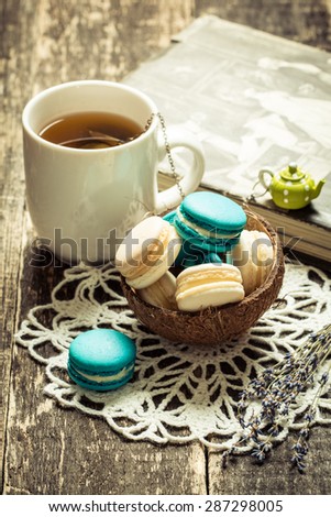 fresh macaroons and tea cup on wooden table .Vintage filter