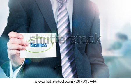 Businessman holding a card with Business written on it.