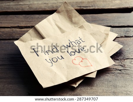 Written message on piece of paper on wooden table close up