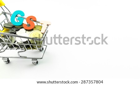 GST or Goods and Services Tax alphabet letters and mini shopping trolley loaded with Malaysian currency coins or shilling. Concept of Government Goods Service Tax. Slightly defocused and close-up shot