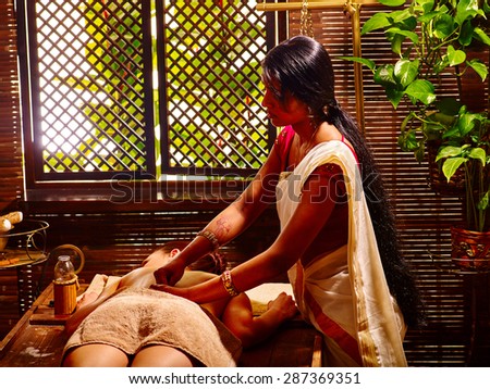 Young woman having oil Ayurveda spa treatment. Day of window.