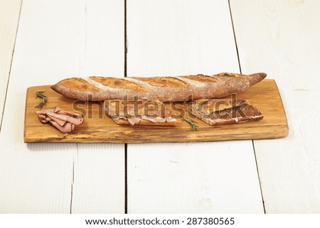 Ham sandwich with herb butter on a wood cutting board. 