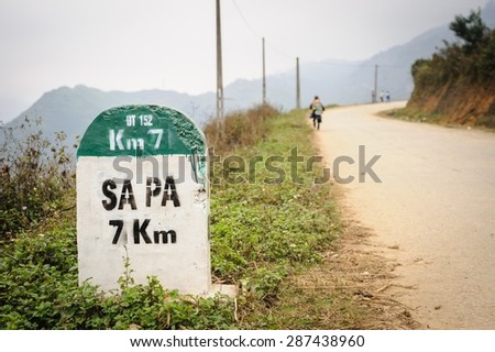 7 kilometer milestone on the highway DT 152 and direction sign to SAPA, north Vietnam. Royalty-Free Stock Photo #287438960