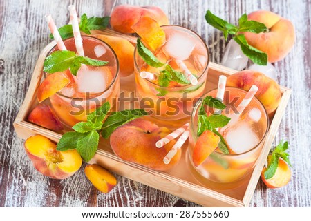 Homemade lemonade with ripe flat saturn-shaped peaches and fresh mint