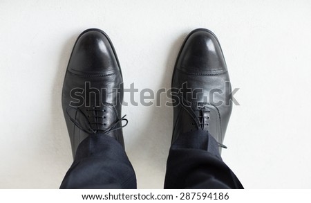 people, business, fashion and footwear concept - close up of man legs in elegant shoes with laces or lace boots Royalty-Free Stock Photo #287594186