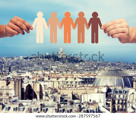 community, unity, people and support concept - couple hands holding paper chain multiracial people over city background