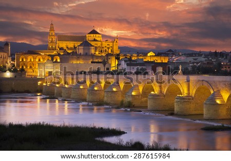 Cordoba - The Roman bridge and the Cathedral in the background at dusk Royalty-Free Stock Photo #287615984