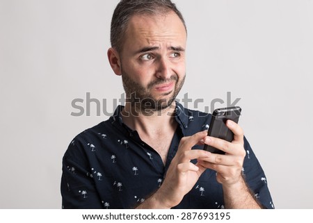 Man holding a phone with funny expression.