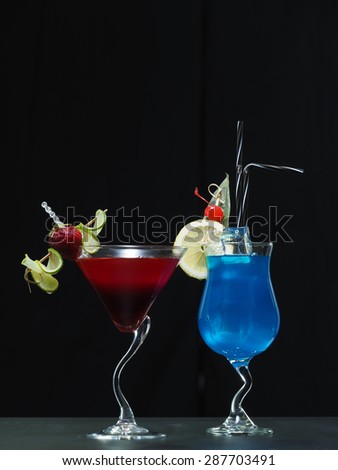 Two cocktails blue and red isolated over black
