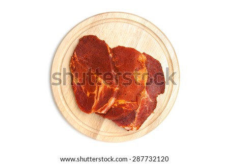 Spiced steaks on chopping board