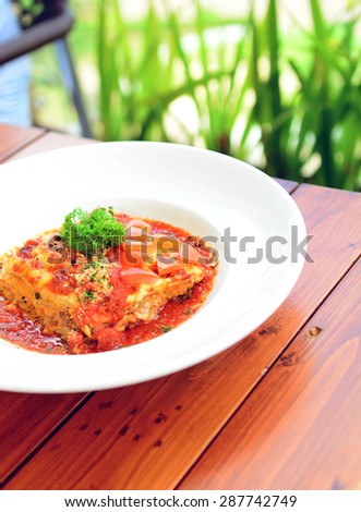 Close up picture of beef lasagna on the wooden table