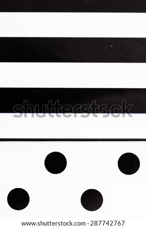 Black and white geometrical painted canvases on white wooden background
