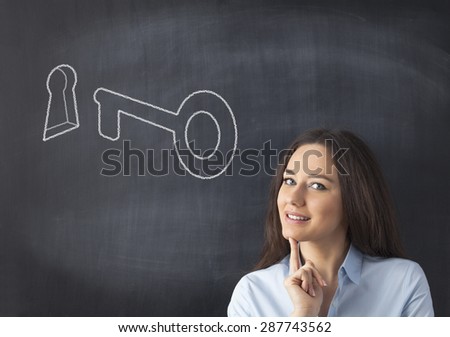 Businesswoman standing and smile front on blackboard, key and keyhole chalk draw on it.