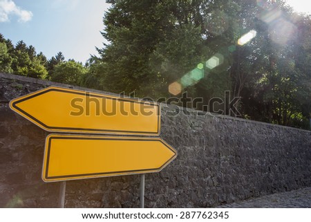 Orange road signs showing two directions without names