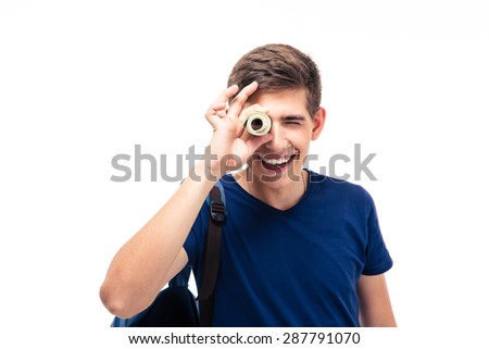 Smiling male student looking at camera through money isolated on a white background