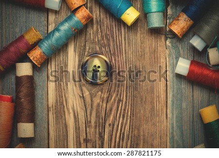 vintage button and spools of thread on old textured boards. instagram image filter retro style