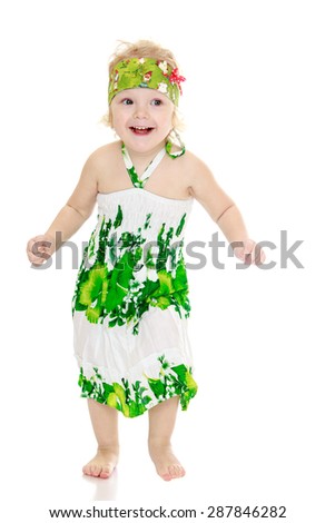 Very funny little girl with bare feet in a long summer dress-isolated on white background