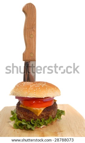 Freshly grilled cheeseburger with a knife running through it