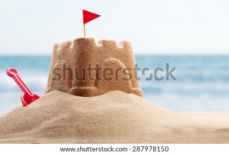 Holiday concept with sandcastle on the seaside Royalty-Free Stock Photo #287978150