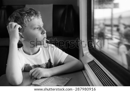 Bored boy with candy look in train window