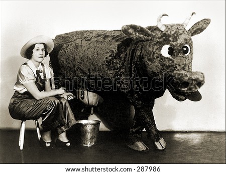 Vintage photo of a Milkmaid Sitting Next To Stuffed Cow