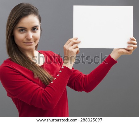 relaxed smart young girl raising a copy space communication board with important news on
