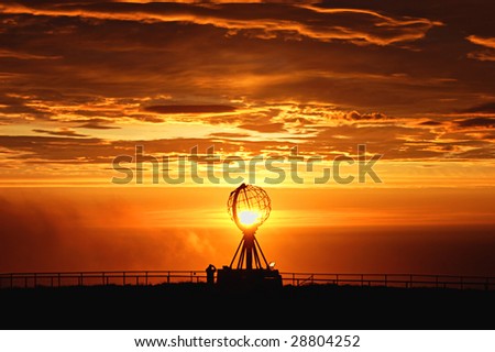 Sun setting over globe sculpture in Nord Cap, the most northen point of Europe Royalty-Free Stock Photo #28804252