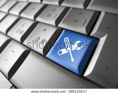 Assistance and computer service concept with toolkit icons and symbol on a blue laptop computer key for website and online business. Royalty-Free Stock Photo #288120617