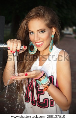 Pretty woman drinking water in the park