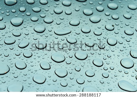 Fresh water droplets on clean glass with storm cloud in background