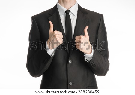 Businessman and gesture topic: a man in a black suit with a tie showing two hands gesture thumbs up isolated on white background in studio