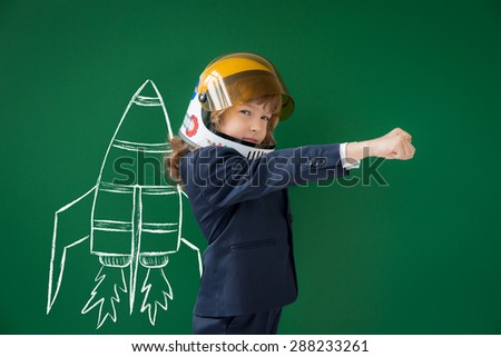 School kid in class. Happy child against green blackboard. Education concept