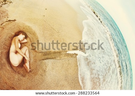 Beautiful Young Woman lying on Sea shore. Ocean as Abstract embodiment of Universe that Cares about People. Global Love concept