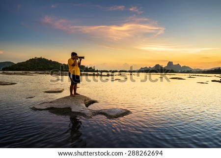 Photographer take a picture of beautiful sunset in lake