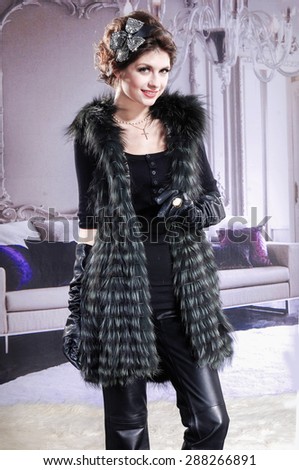 High fashion model in fur coat posing 