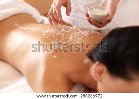 Spa Woman. Brunette Getting a Salt Scrub Beauty Treatment in the Health Spa. Body Scrub. Royalty-Free Stock Photo #288266972