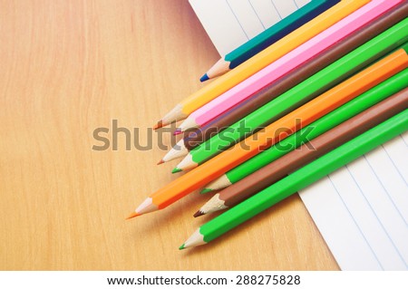 colored pencils on a notebook in line
