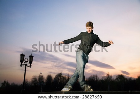 Roller man sliding outdoor at sunset